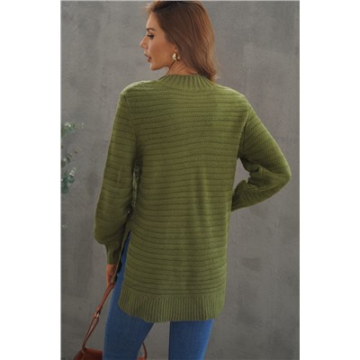 Зеленый свитер крупной вязки с воротником стойка и боковыми разрезами